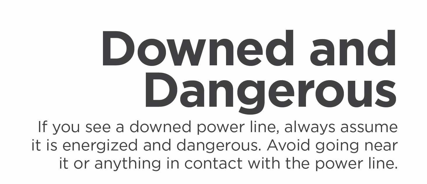 A safety sign warns about downed power lines, stating they are dangerous. The message advises avoiding contact with such lines for safety.