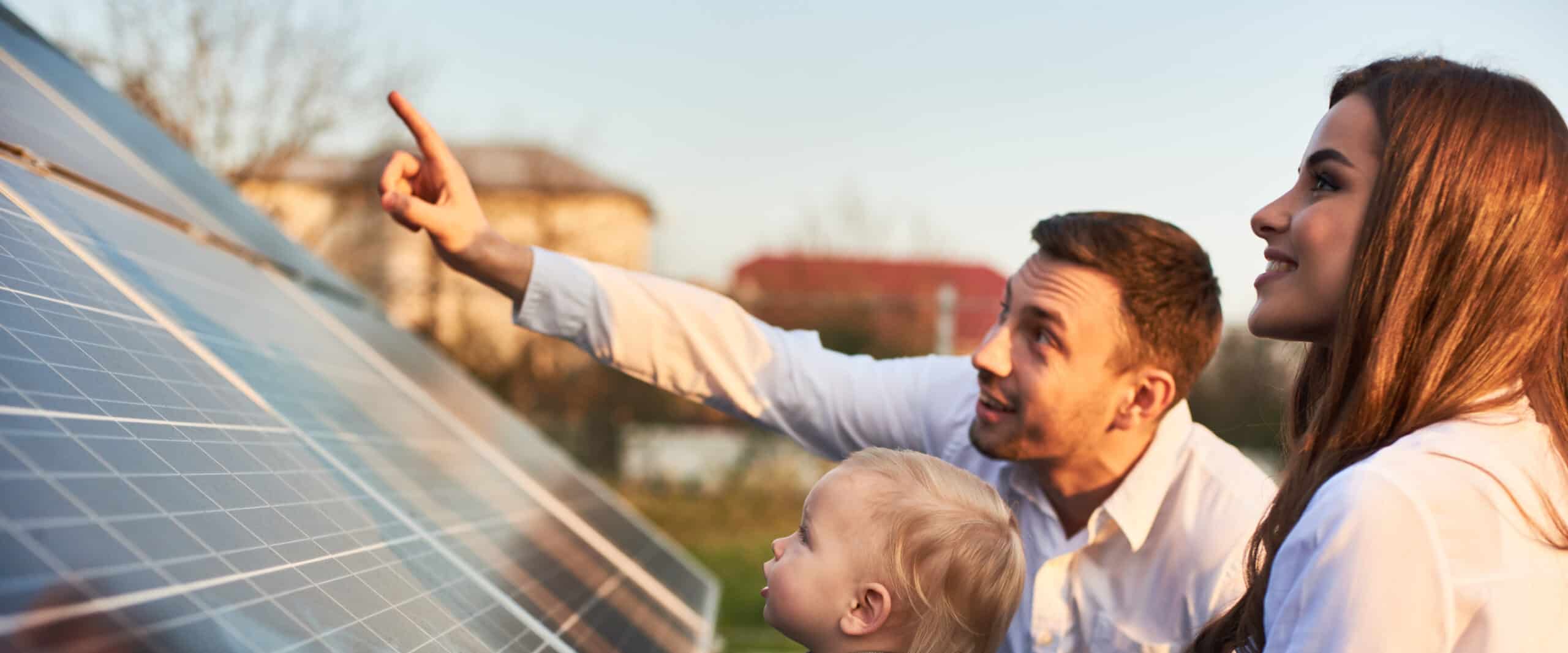 Young family looking at solar panel.