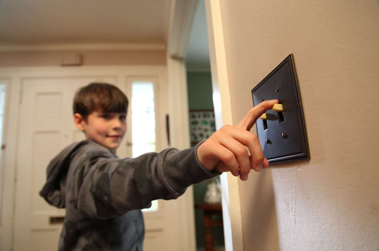 Young man is seen switching off the lights to save energy.